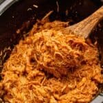 Shredded Chicken breasts in slow cooker tossed with BBQ sauce.