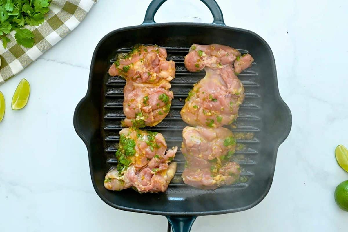 Grilled Cilantro Lime Chicken Four chicken thighs marinated in cilantro lime marinade on grill pan.