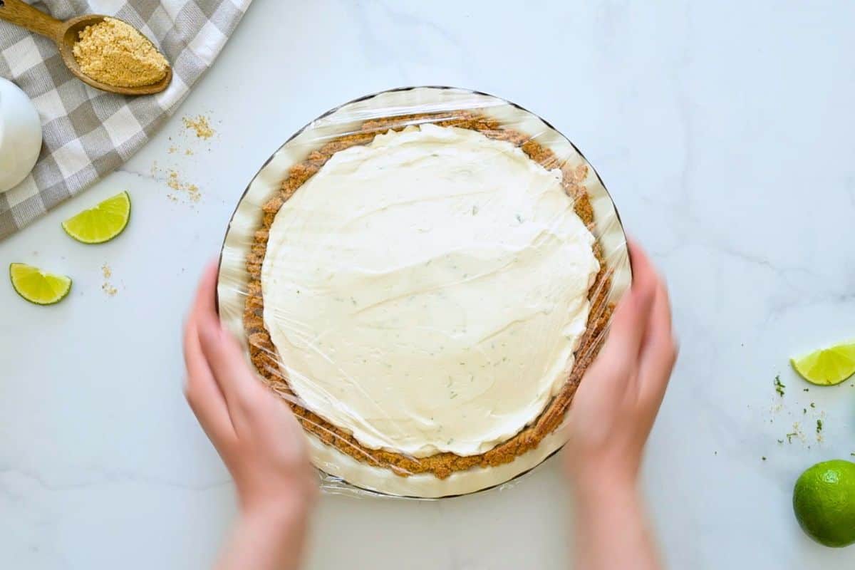 Easy Key Lime Pie with Homemade Graham Cracker Crust Key Lime pie assembled in homemade crust covered with plastic wrap before chilling.