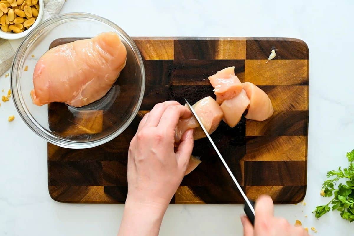Chicken Kabobs Recipe Cutting chicken breasts into 2-inch cubes for chicken kabobs.