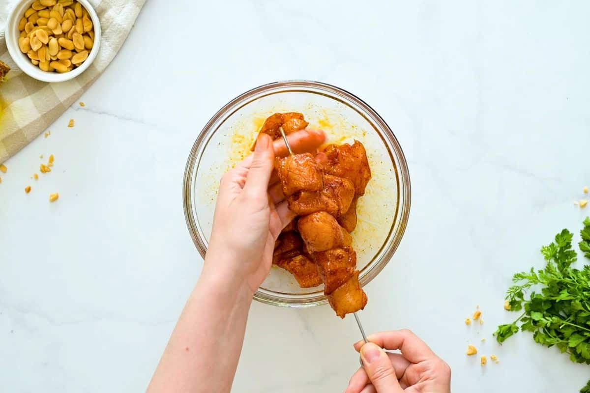 Sweet and Spicy Chicken Kabobs Threading cubes of spice rubbed chicken onto metal skewers.