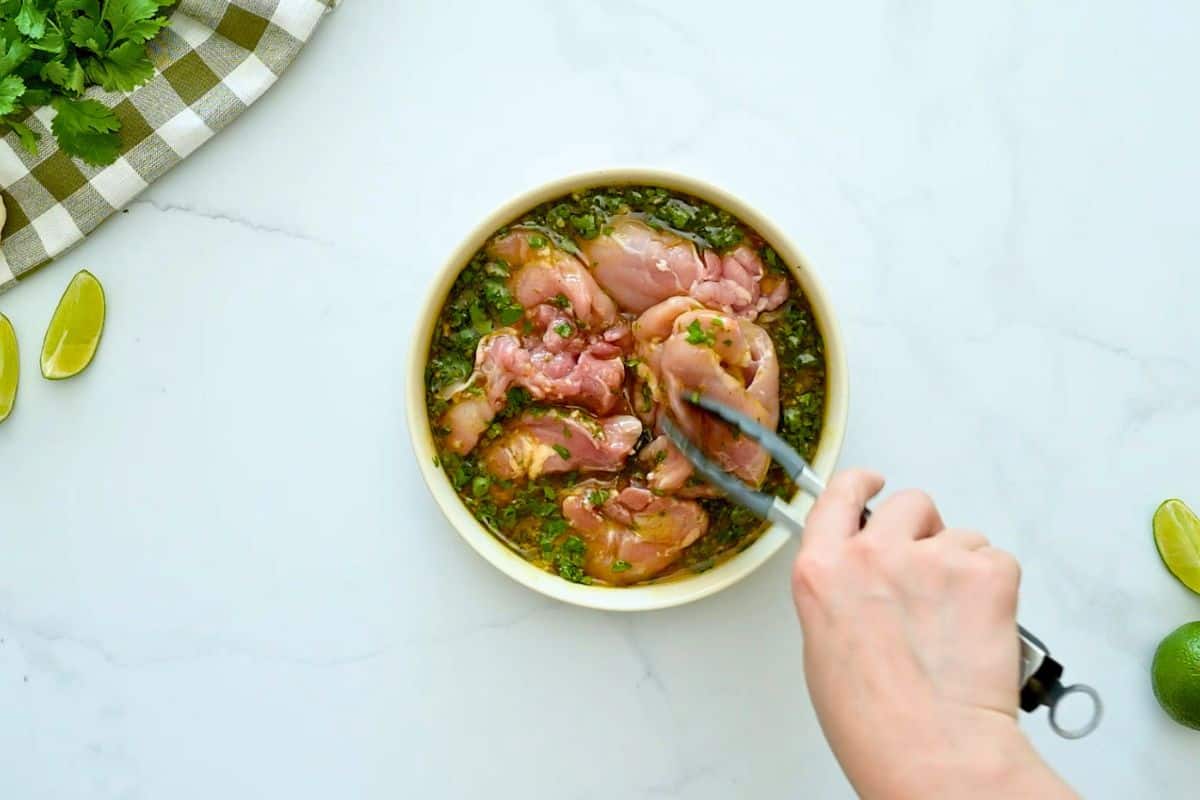 Easy Chicken Marinade with Cilantro Turning chicken thighs in cilantro lime marinade halfway through marinating process.