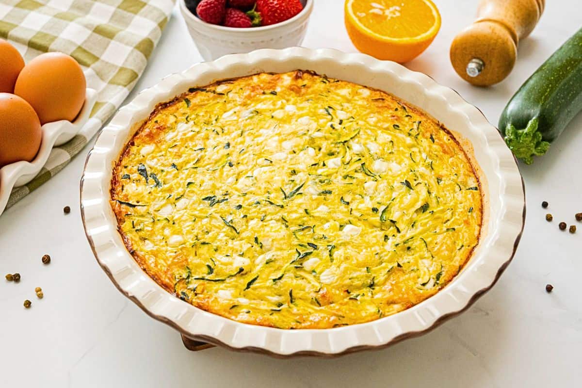 Zucchini Egg Bake with Cottage Cheese Crustless zucchini pie made with shredded zucchini, grated onion, cottage cheese and eggs baked in white ceramic pie dish.