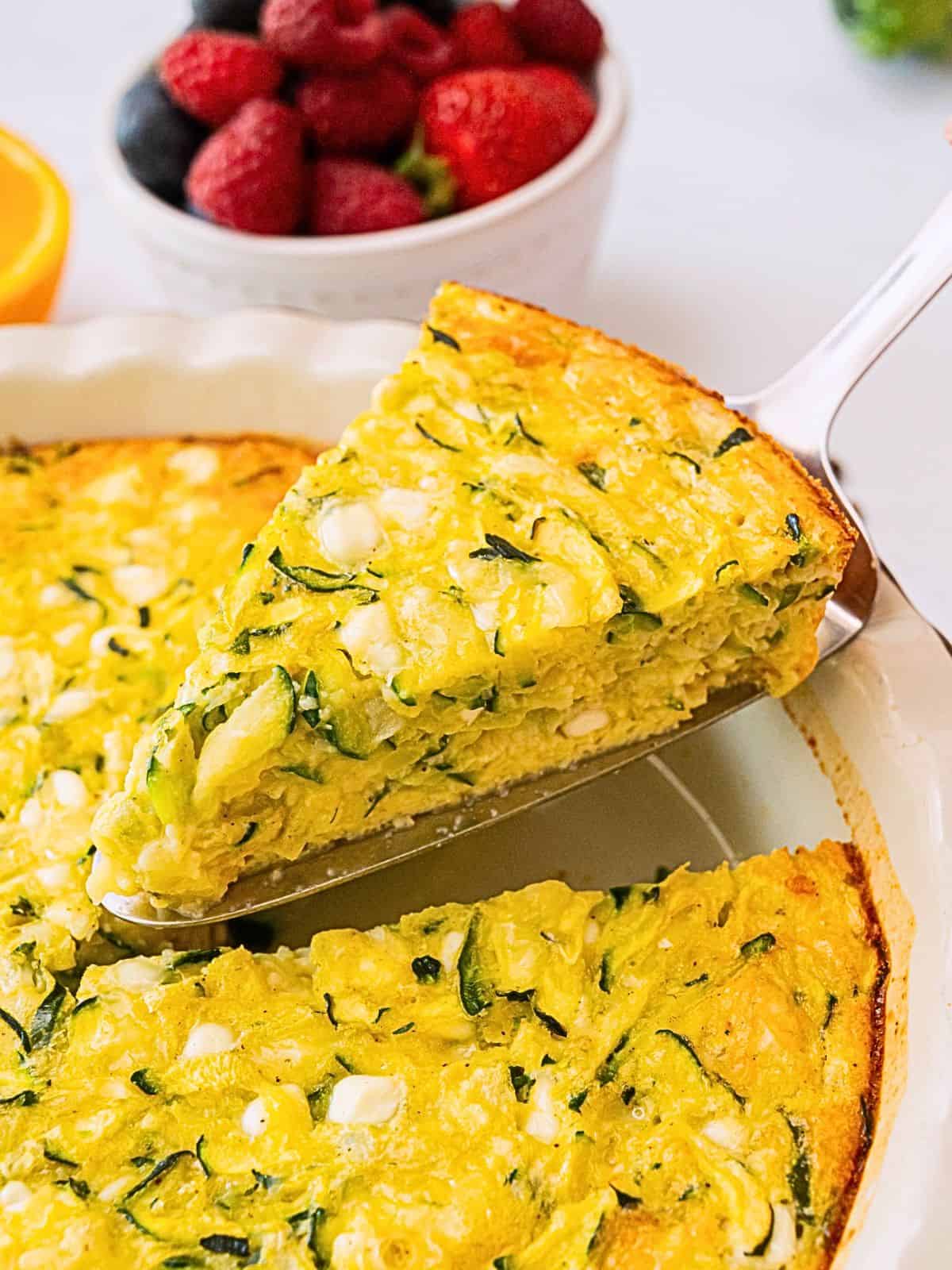 Crustless Zucchini Pie Recipe Spatula pulling out slice of crustless zucchini pie from pie plate.