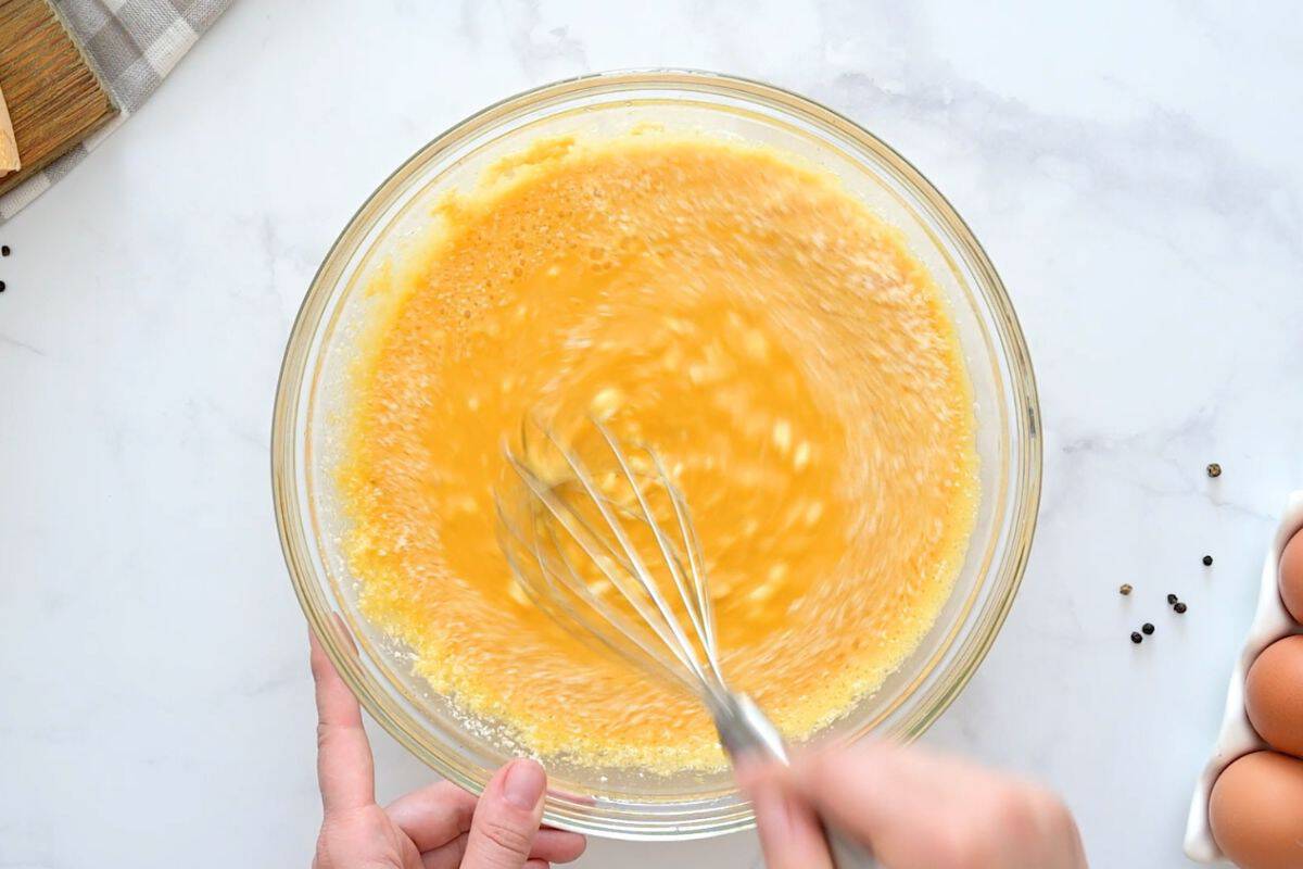 Cottage Cheese and Egg Bake Whisk mixing cottage cheese, parmesan, and shredded cheese into eggs in large mixing bowl.