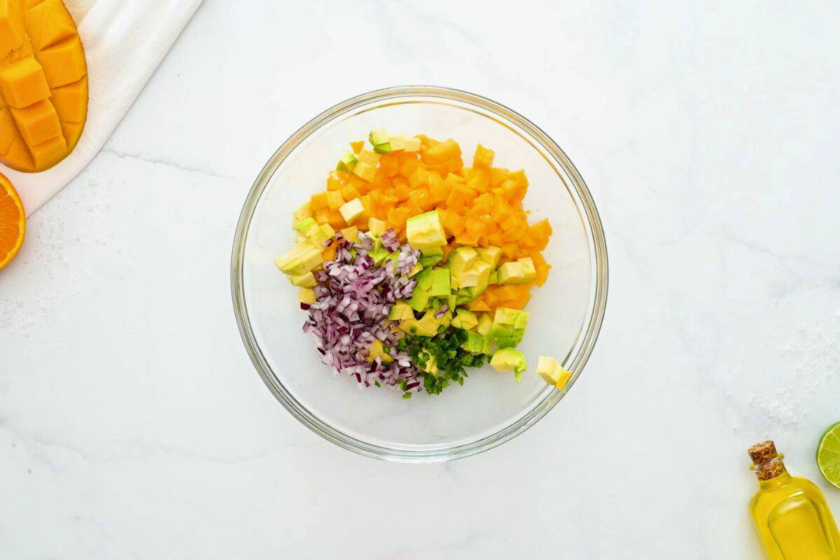 Diced mango, diced avocado, minced red onion, minced jalapeno, lime juice, salt, and cilantro combined in mixing bowl.