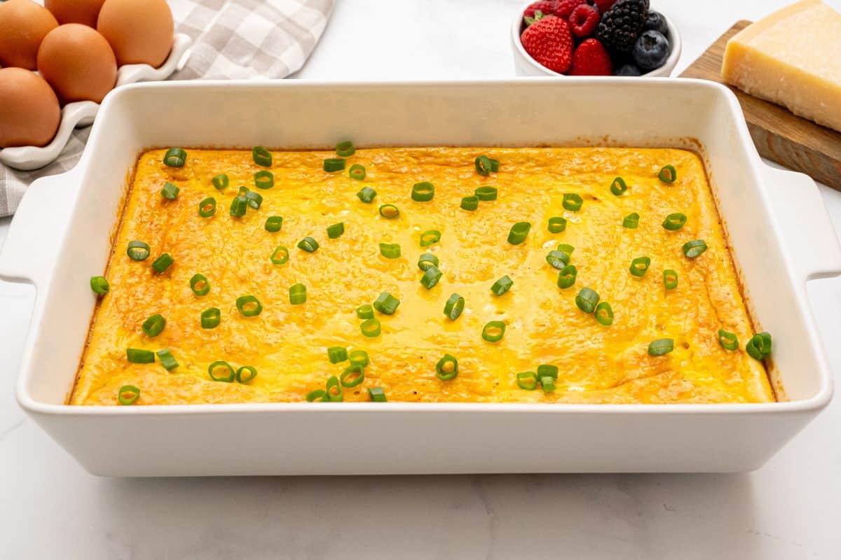 Egg Bake with Cottage Cheese Baked Eggs with cottage cheese in white baking dish topped with sliced green onions.
