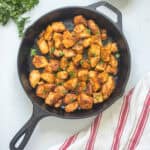 Cubed pieces of chicken breast seasoned, pan-fried, and tossed in hot sauce and butter in cast iron skillet.