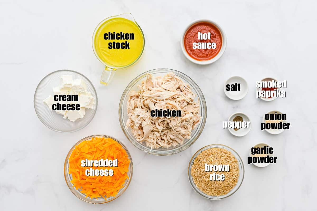 Buffalo Chicken Rice Recipe Chicken, brown rice, shredded cheese, hot sauce and seasonings labeled on counter.