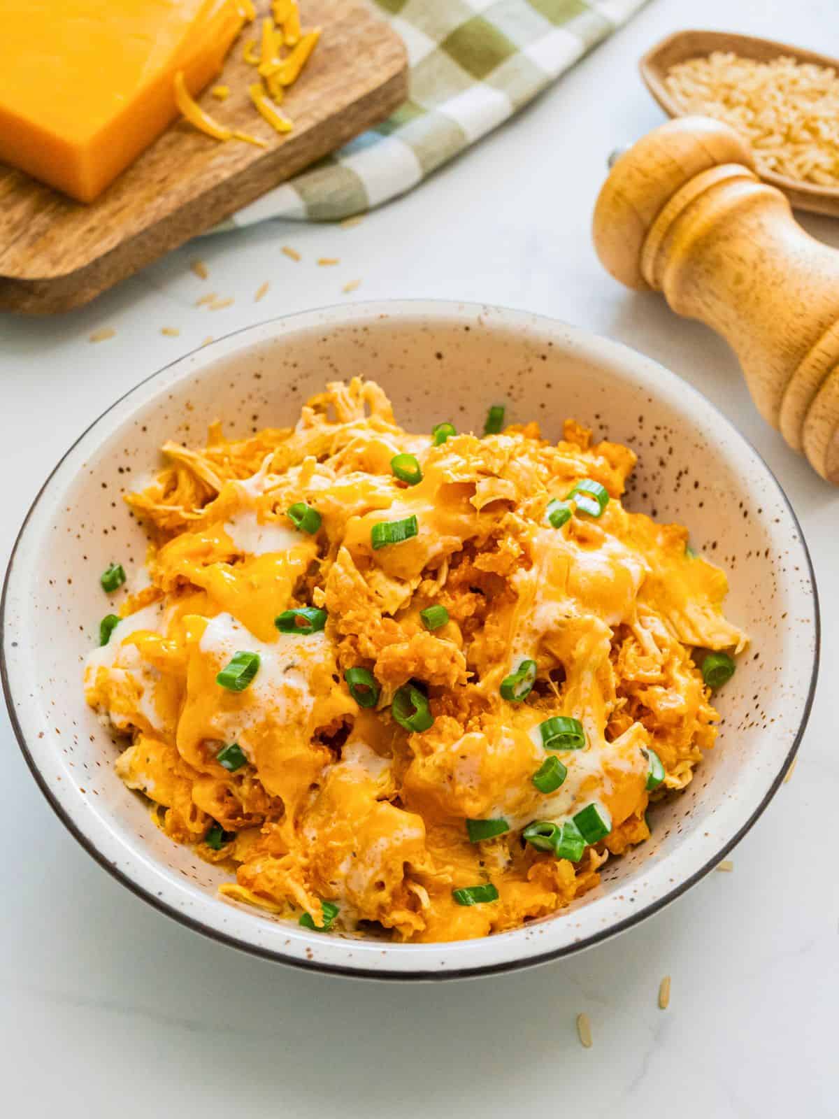 Buffalo flavored chicken and rice dished out in bowl with drizzle of ranch dressing.