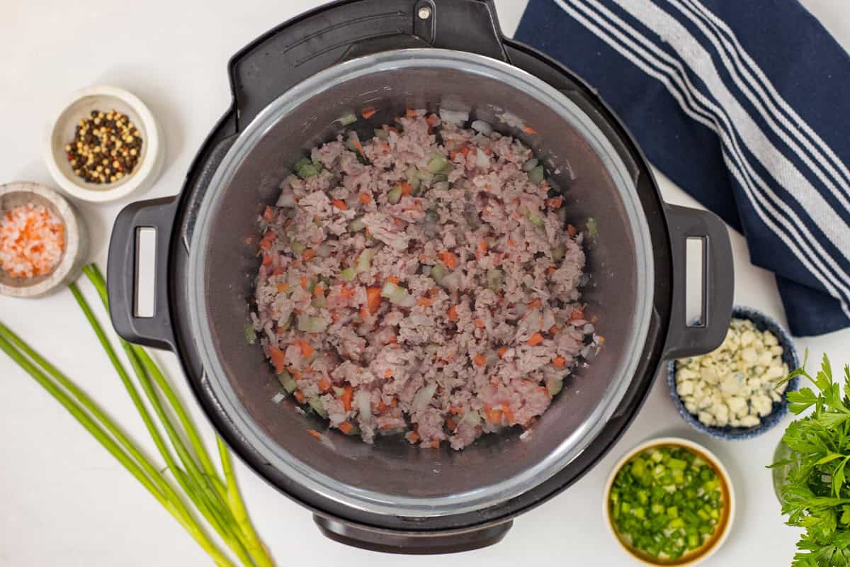 Buffalo Chicken Chili with Ground Chicken Ground chicken sauteed with onions, carrots, and celery inside instant pot.