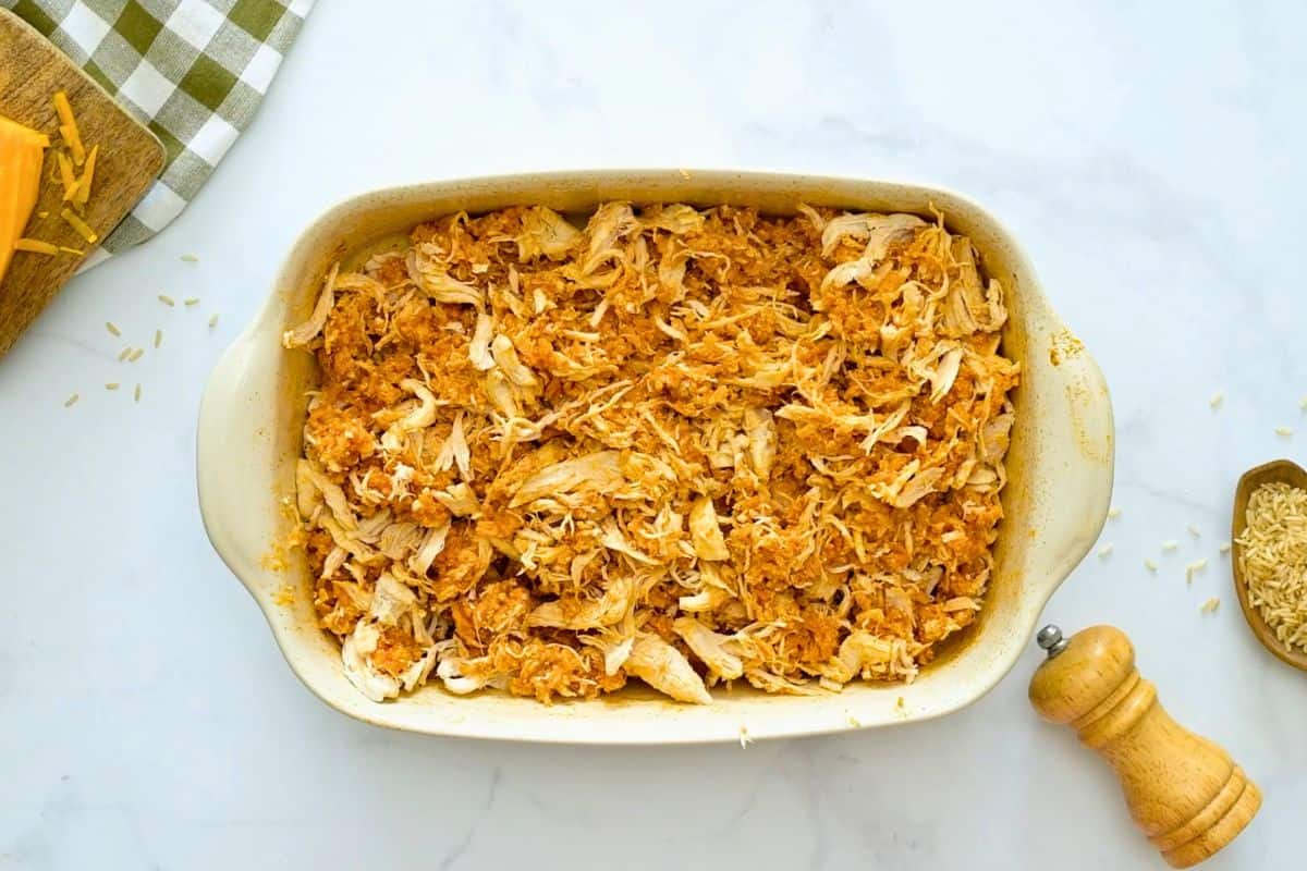 Chicken and Rice with Buffalo Sauce and Cream Cheese Shredded chicken mixed into buffalo flavored rice in casserole dish.