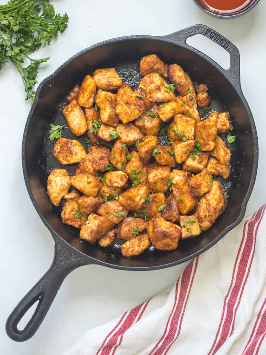 Buffalo Chicken Bites Cubed chicken breast pan-fried and coated in buttery hot sauce mixture in cast iron skillet.