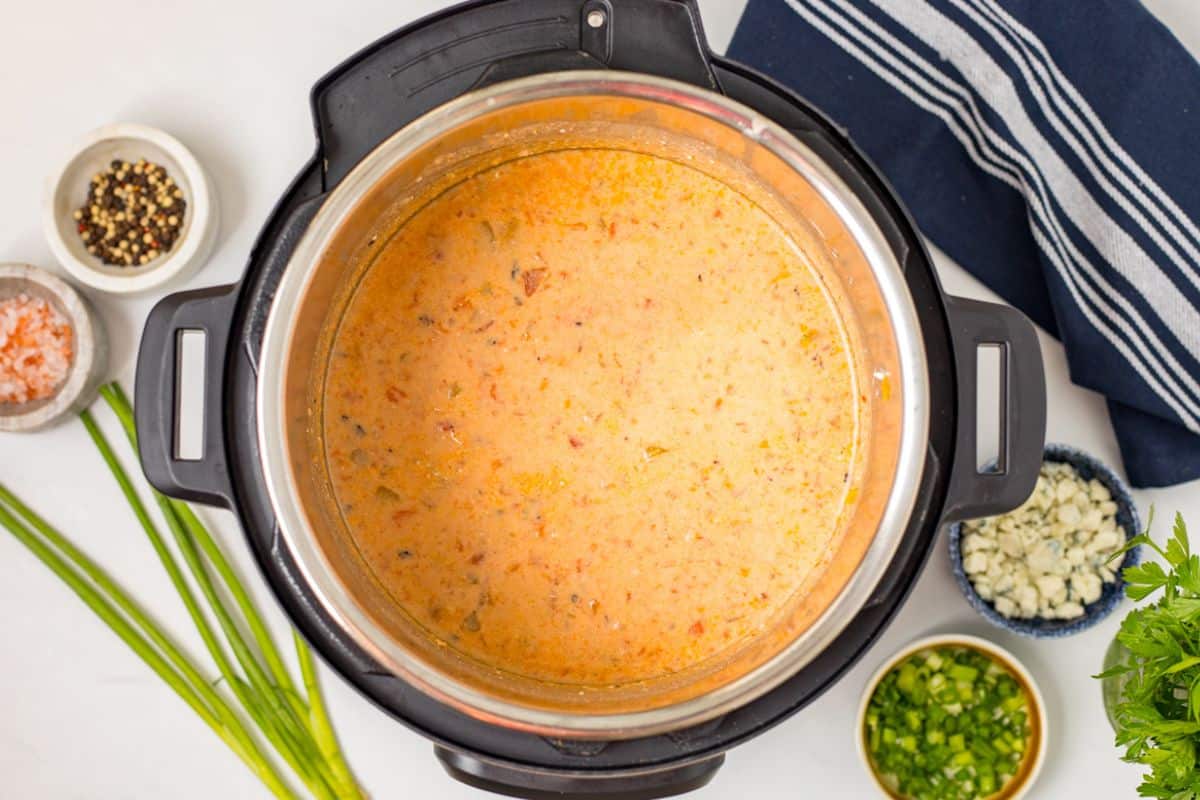 Buffalo Chicken Chili with Cream Cheese Cream cheese whisked into buffalo chicken chili until melted and creamy.