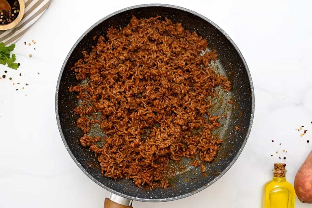 Sweet Potato Bowls with Taco meat Ground beef seasoned with taco seasoning and tomato sauce in skillet.