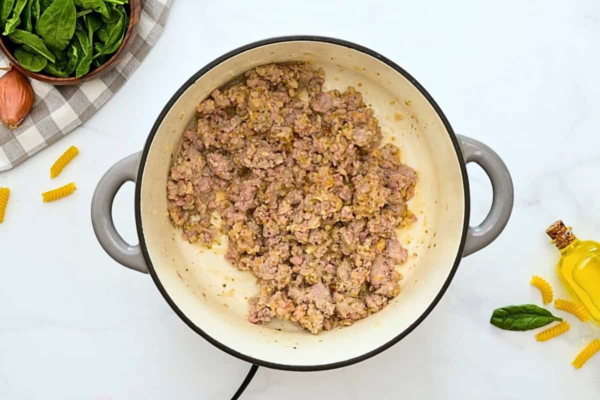 Browned Italian sausage with minced shallots in large stockpot after wine added and reduced by half.